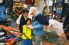 (c) Copyright - Raphael Kessler 2011 - Ecuador - Otavalo - Dad shows the locals photos of the locals